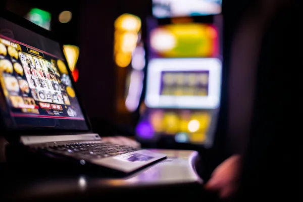 A woman smiling by bright slot machines showing lucky symbols, showcasing the exciting slot offerings at 786BED.